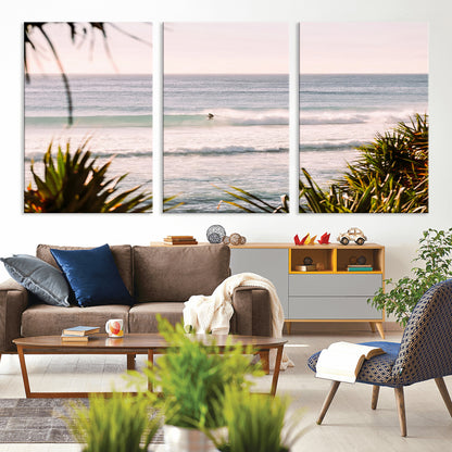 Canvas of a lone surfer riding a pastel wave at sunrise, perfect for tropical or coastal-themed spaces with a relaxed, airy vibe.