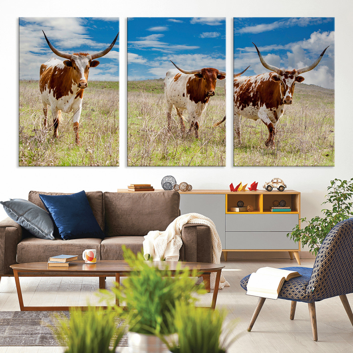 Three Texas longhorn cattle standing in dry grass under a bright blue sky, ideal for farmhouse or western rustic home decor.