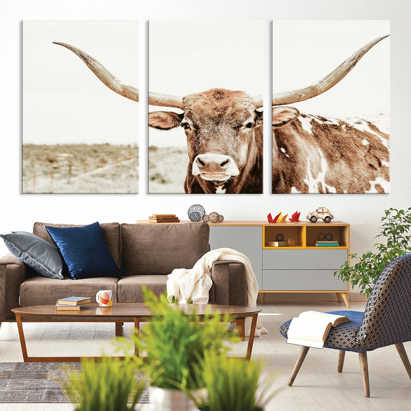 A Texas longhorn bull with wide horns, standing in a dry field under soft light, ideal for rustic farmhouse or western-themed interiors.