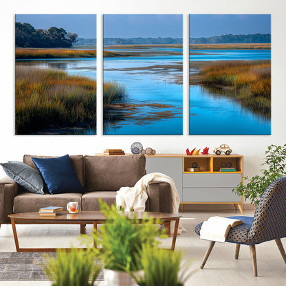A peaceful marshland scene with calm blue water reflecting the surrounding grasses and trees, capturing the beauty of nature in a serene landscape.