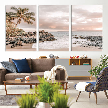 A peaceful beach scene with a palm tree and rocks, soft waves washing onto the shore under a soft pastel sky at sunset.