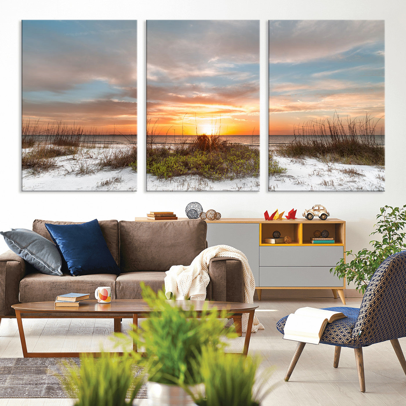 A tranquil beach scene featuring golden sunset hues over the water, with grasses in the foreground and a peaceful, serene atmosphere.
